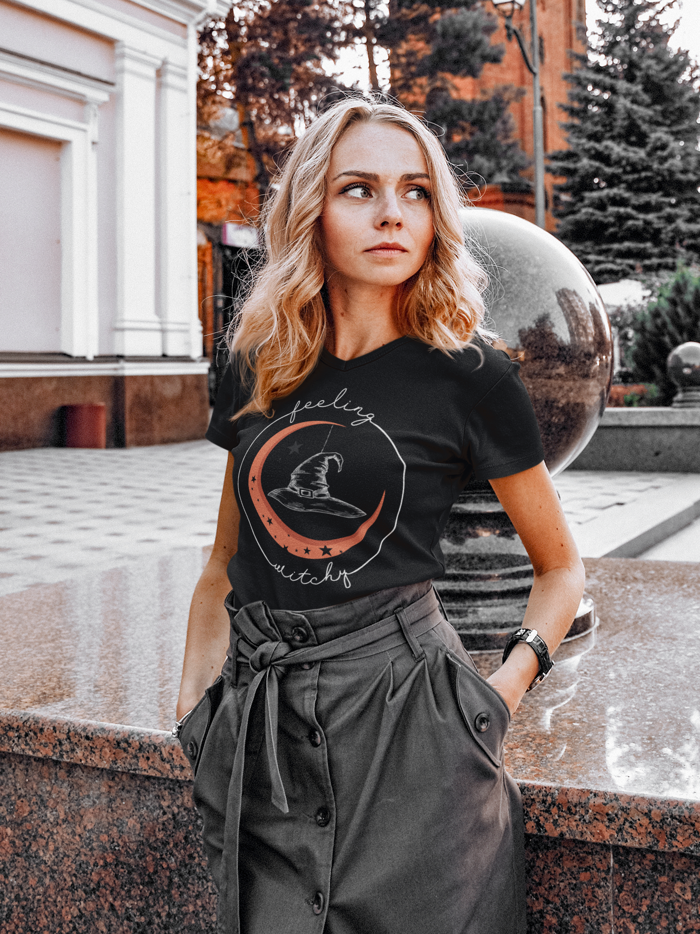 Woman wearing Halloween Feeling Witchy moon and black hat short sleeve unisex black tee shirt