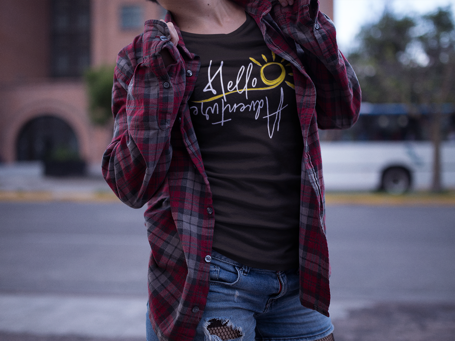 woman wearing plaid shirt and hello adventure shirt
